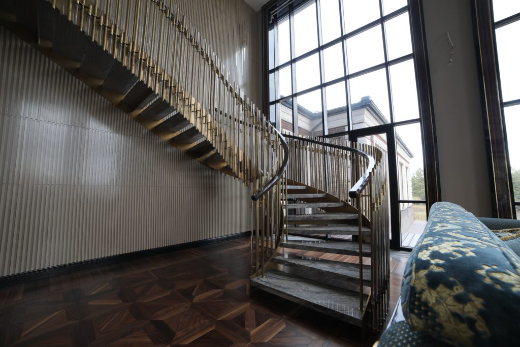 Винтовая лестница с ограждением из латуни и стекла